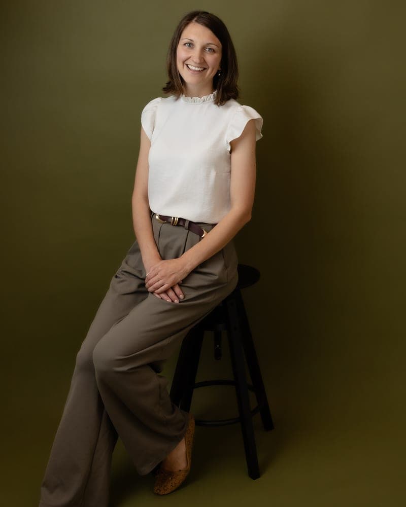 Marni seated on a stool, smiling